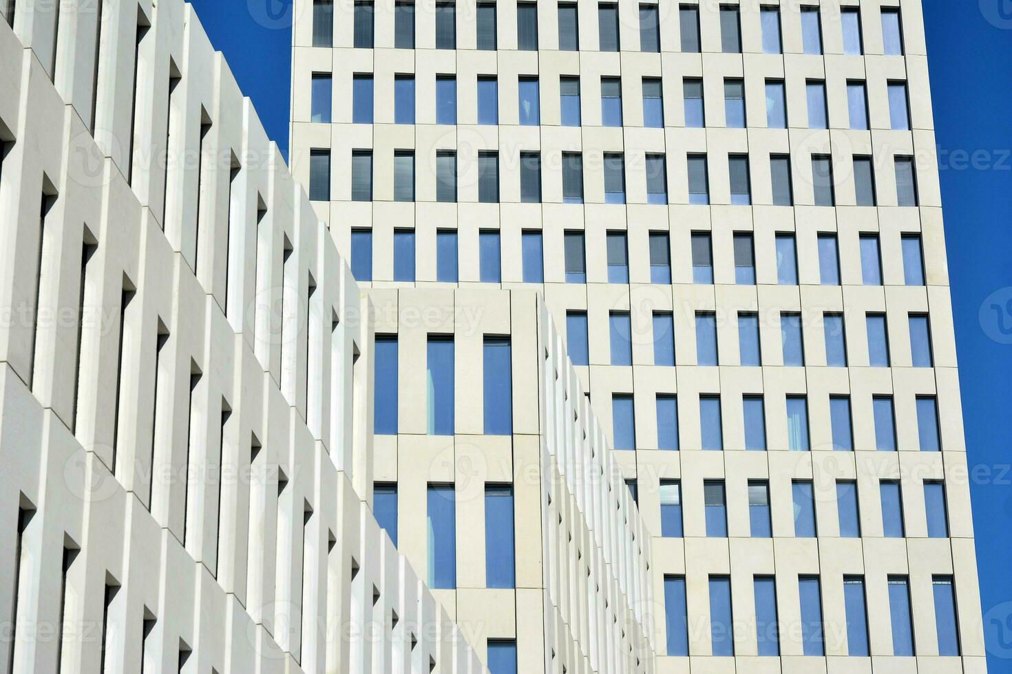 Modern office building detail. Perspective view of geometric angular concrete windows on the facade of a modernist brutalist style building. photo