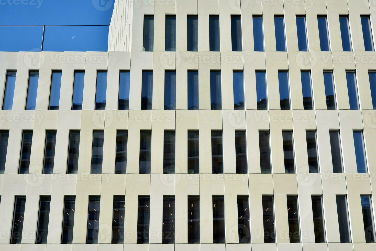 Modern office building detail. Perspective view of geometric angular concrete windows on the facade of a modernist brutalist style building. photo