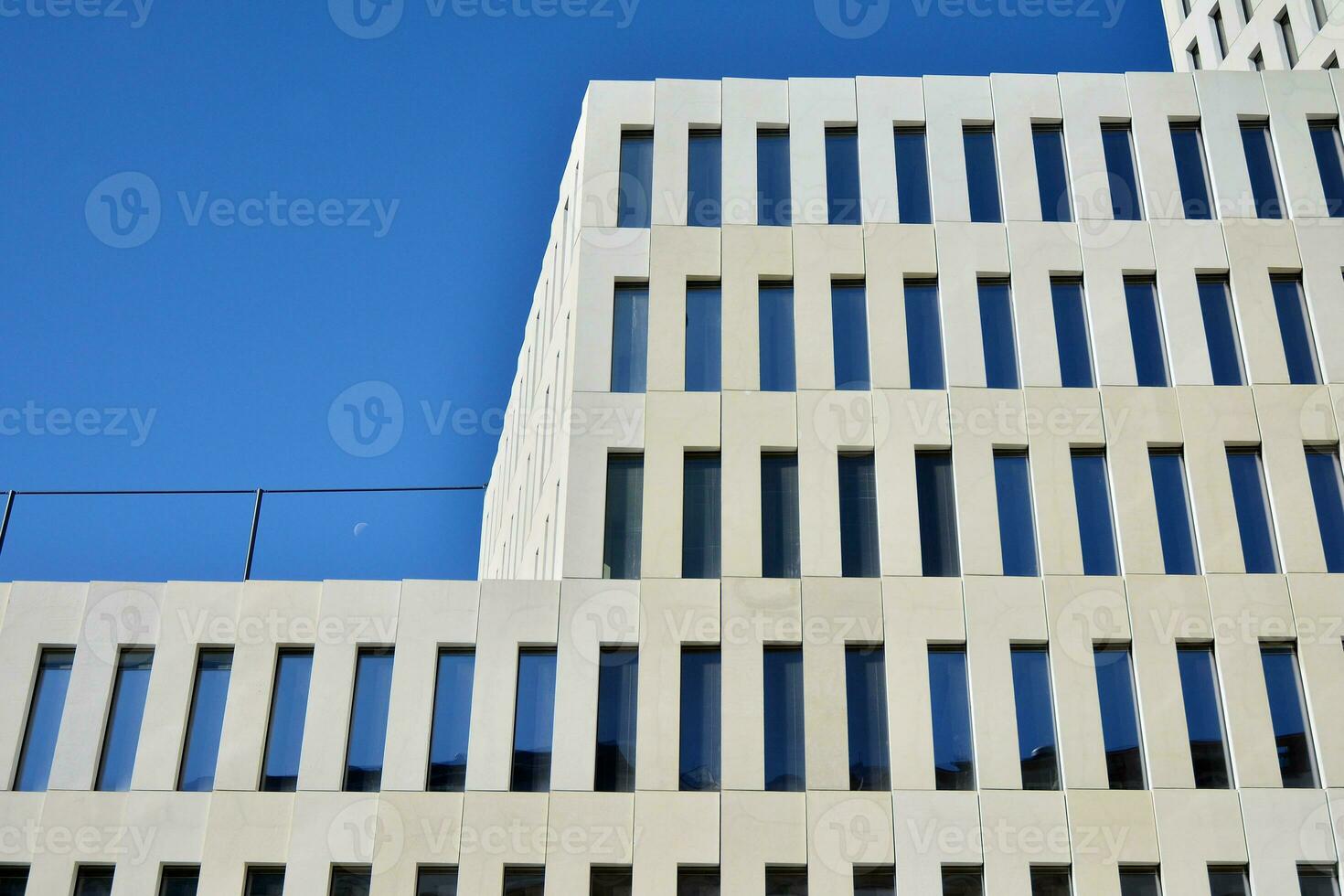 Modern office building detail. Perspective view of geometric angular concrete windows on the facade of a modernist brutalist style building. photo