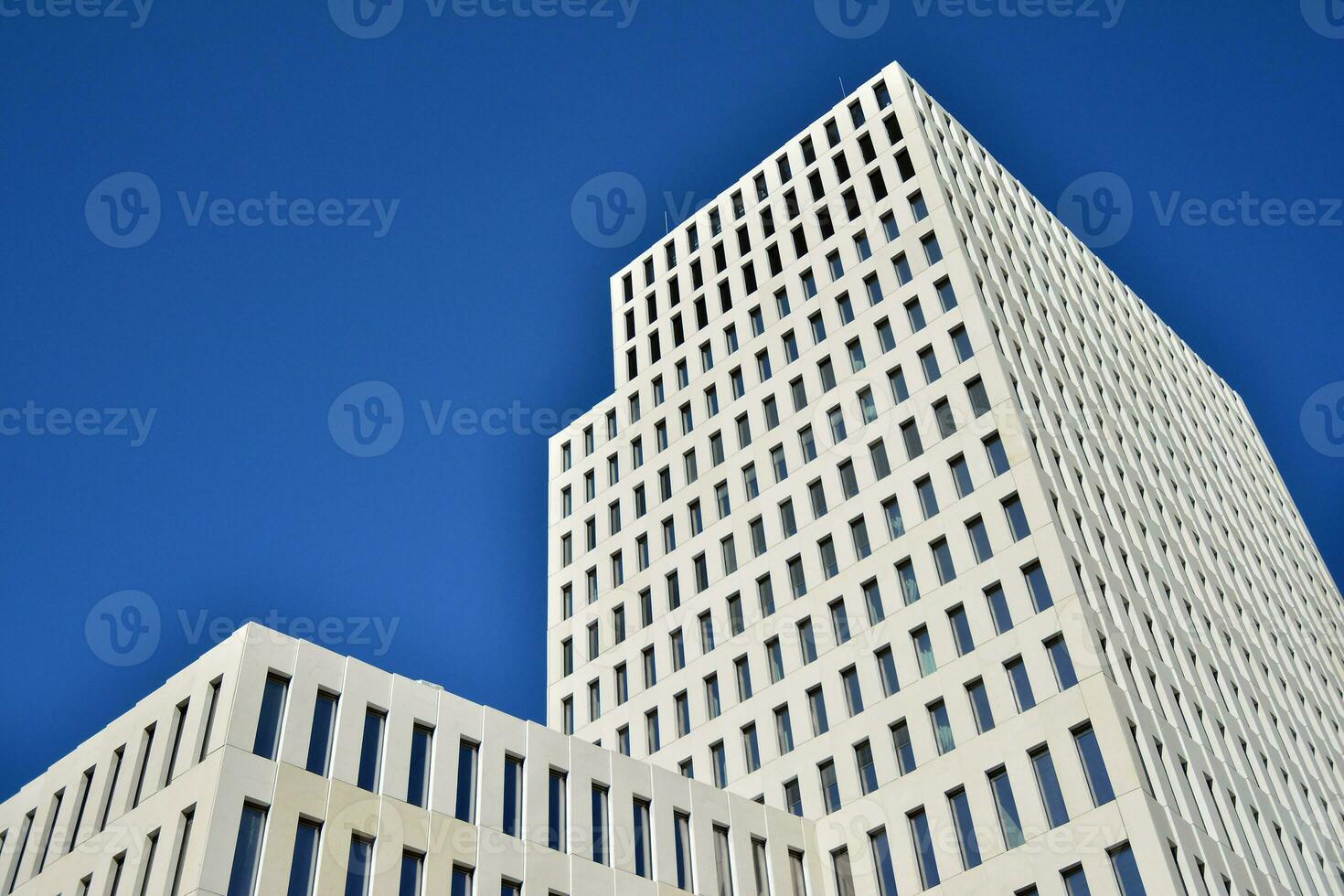 Modern office building detail. Perspective view of geometric angular concrete windows on the facade of a modernist brutalist style building. photo