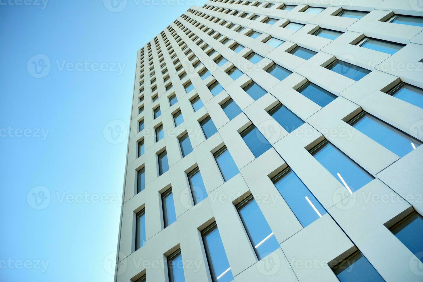 Modern office building detail. Perspective view of geometric angular concrete windows on the facade of a modernist brutalist style building. photo