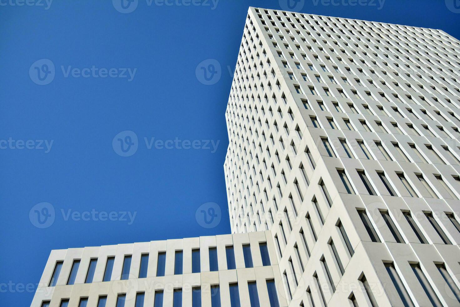 Modern office building detail. Perspective view of geometric angular concrete windows on the facade of a modernist brutalist style building. photo