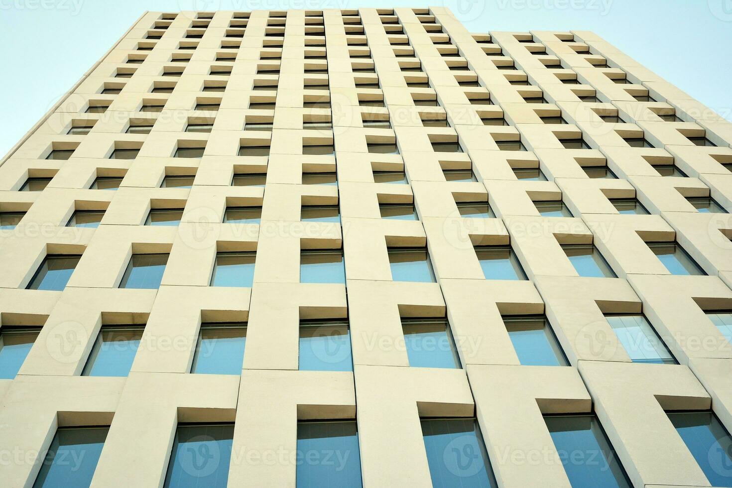 Modern office building detail. Perspective view of geometric angular concrete windows on the facade of a modernist brutalist style building. photo