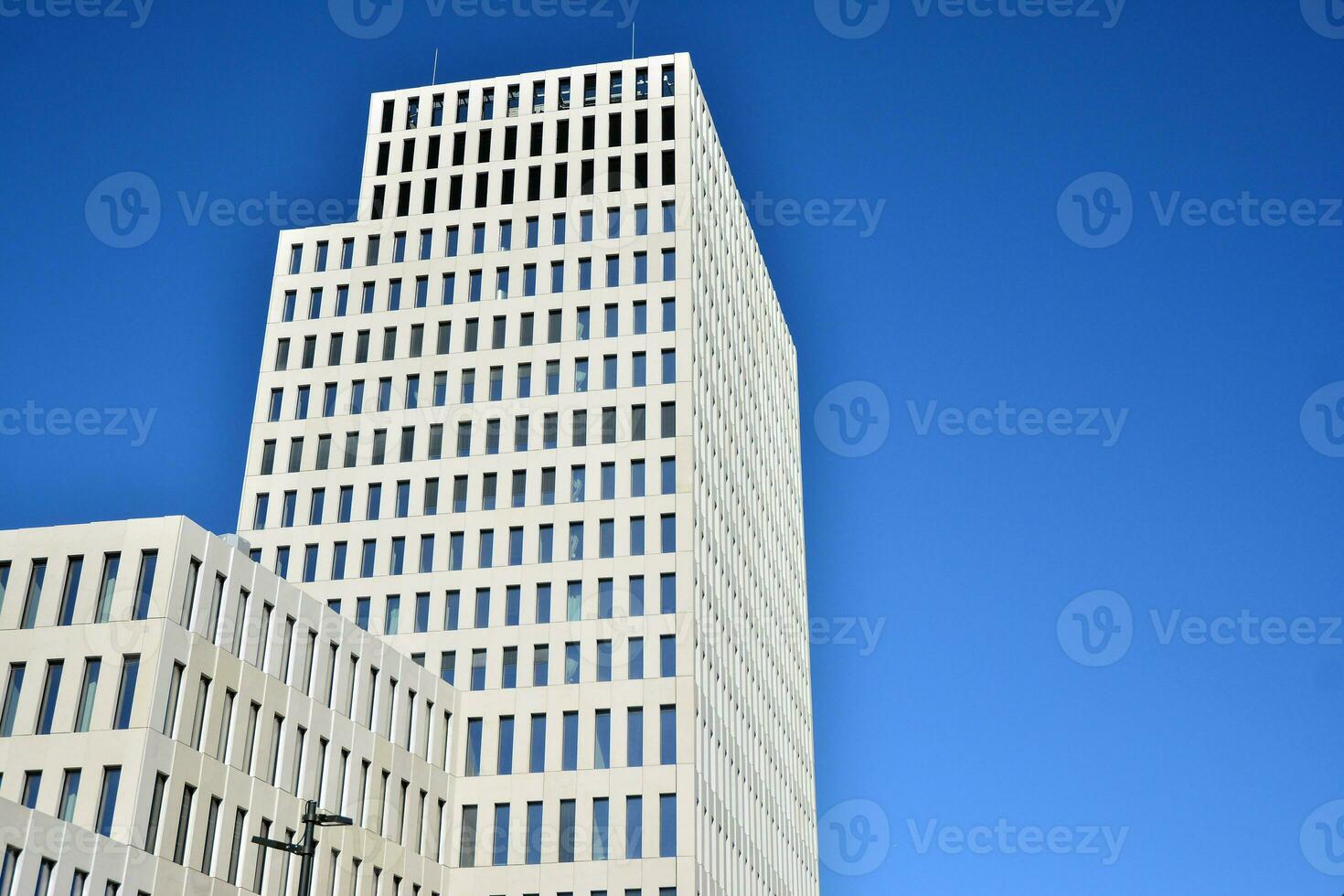 Modern office building detail. Perspective view of geometric angular concrete windows on the facade of a modernist brutalist style building. photo