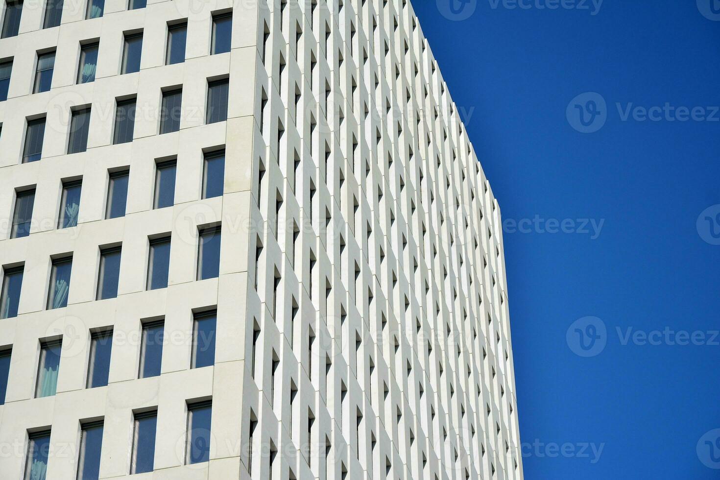 Modern office building detail. Perspective view of geometric angular concrete windows on the facade of a modernist brutalist style building. photo