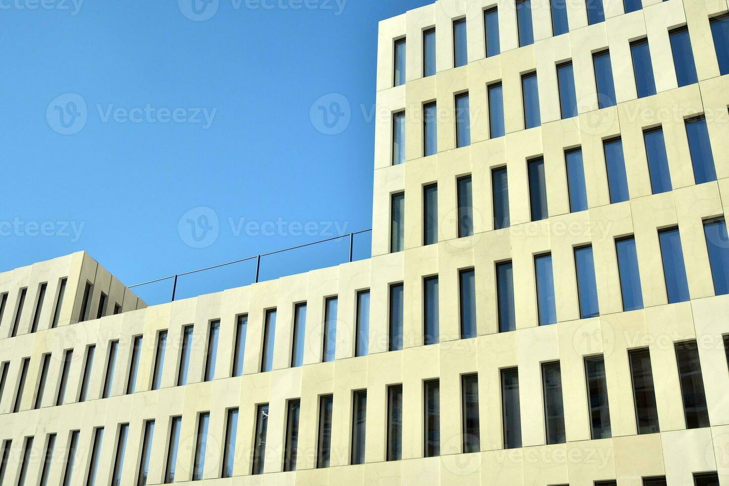 Modern office building detail. Perspective view of geometric angular concrete windows on the facade of a modernist brutalist style building. photo
