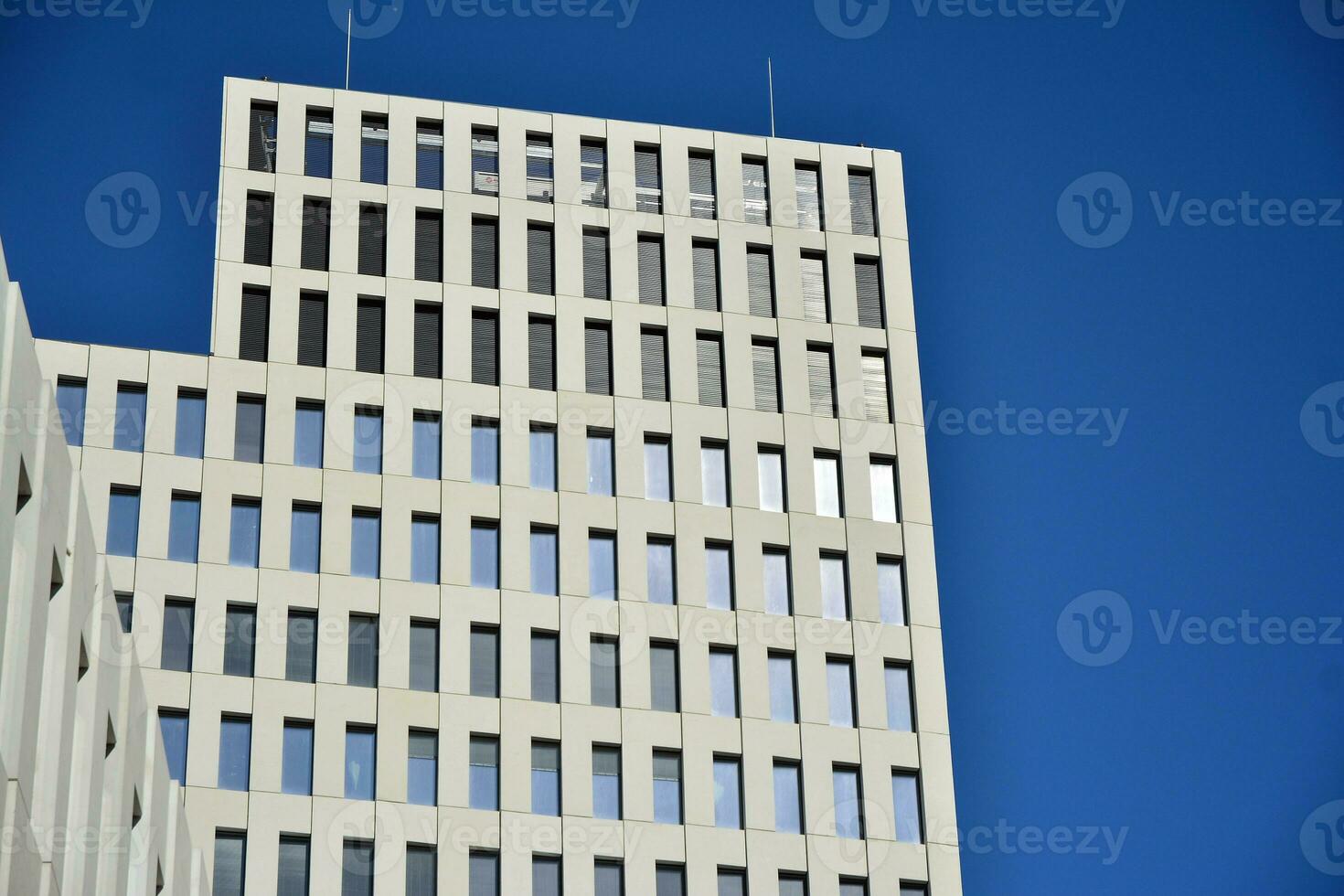 Modern office building detail. Perspective view of geometric angular concrete windows on the facade of a modernist brutalist style building. photo