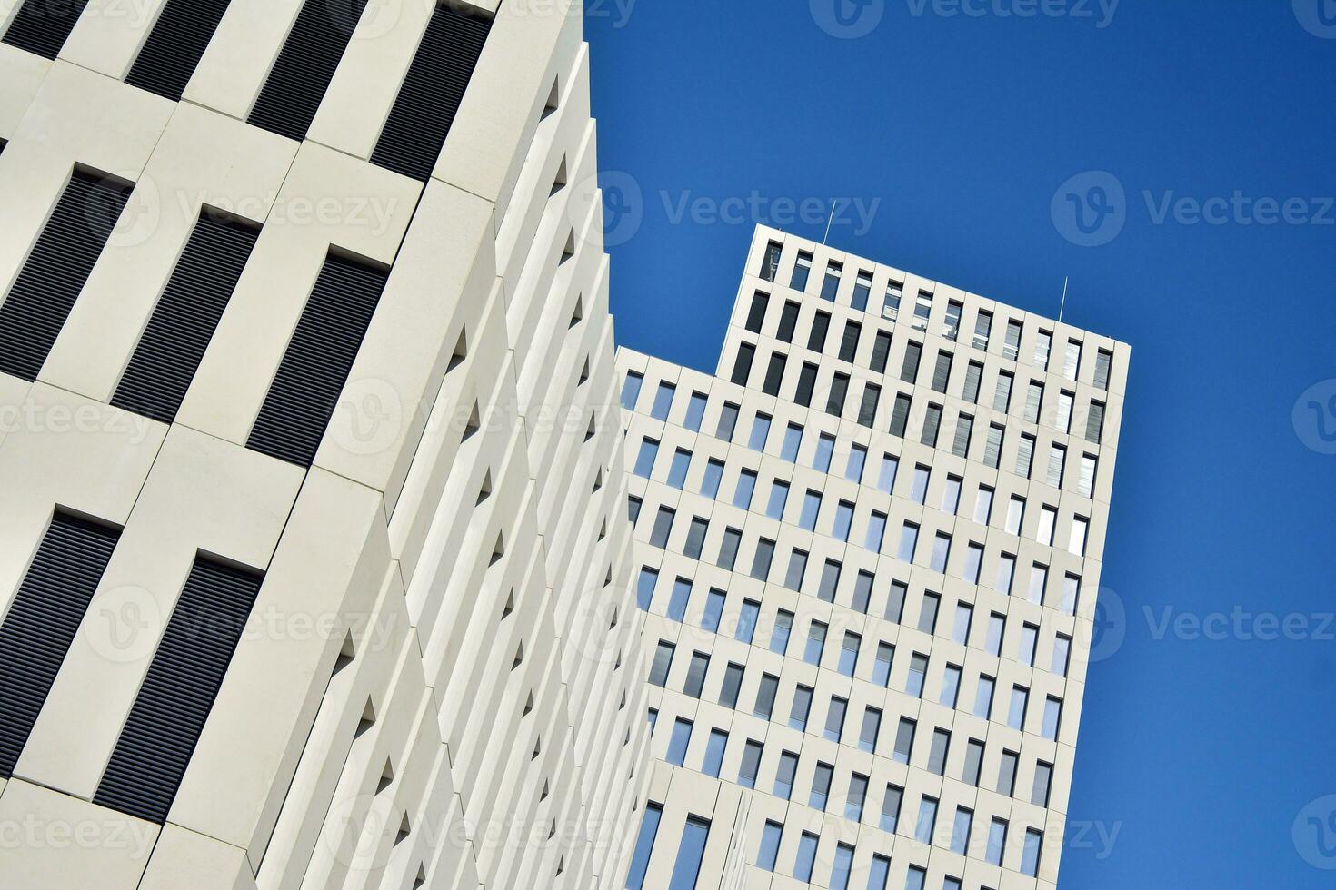 Modern office building detail. Perspective view of geometric angular concrete windows on the facade of a modernist brutalist style building. photo