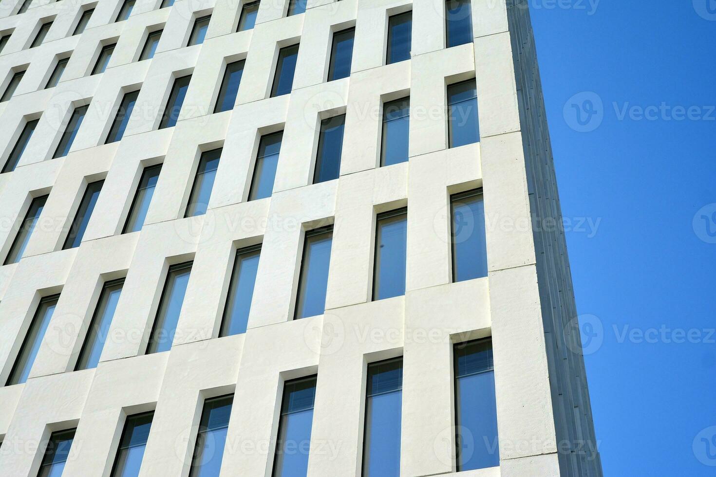 Modern office building detail. Perspective view of geometric angular concrete windows on the facade of a modernist brutalist style building. photo