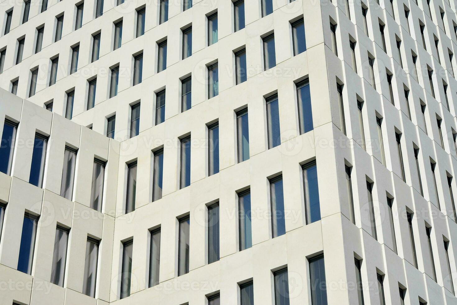 Modern office building detail. Perspective view of geometric angular concrete windows on the facade of a modernist brutalist style building. photo