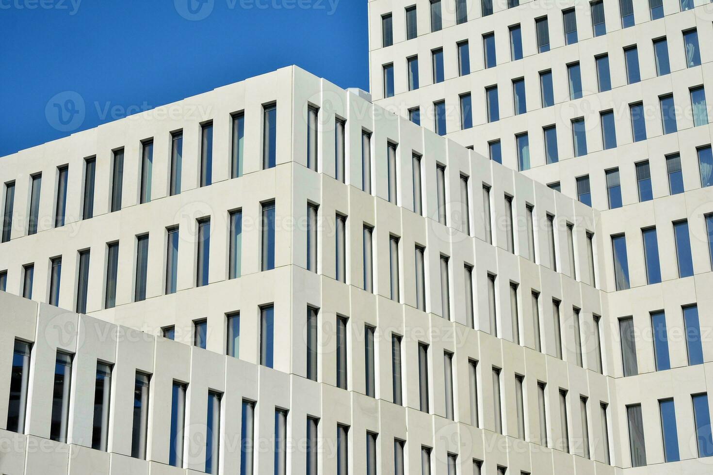 Modern office building detail. Perspective view of geometric angular concrete windows on the facade of a modernist brutalist style building. photo