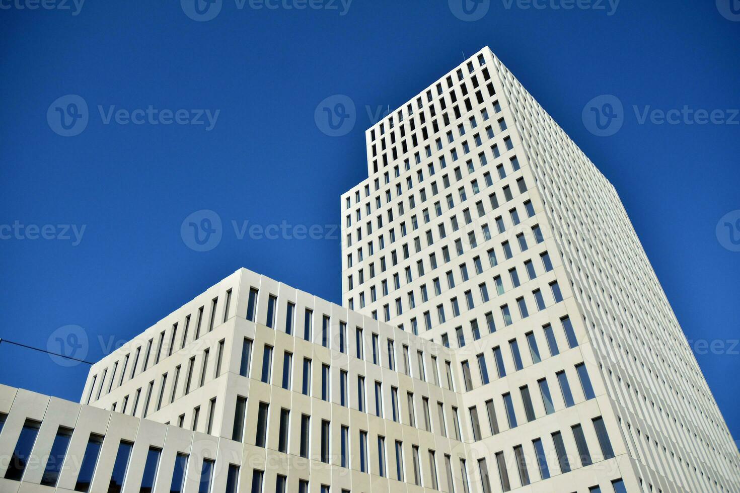 Modern office building detail. Perspective view of geometric angular concrete windows on the facade of a modernist brutalist style building. photo