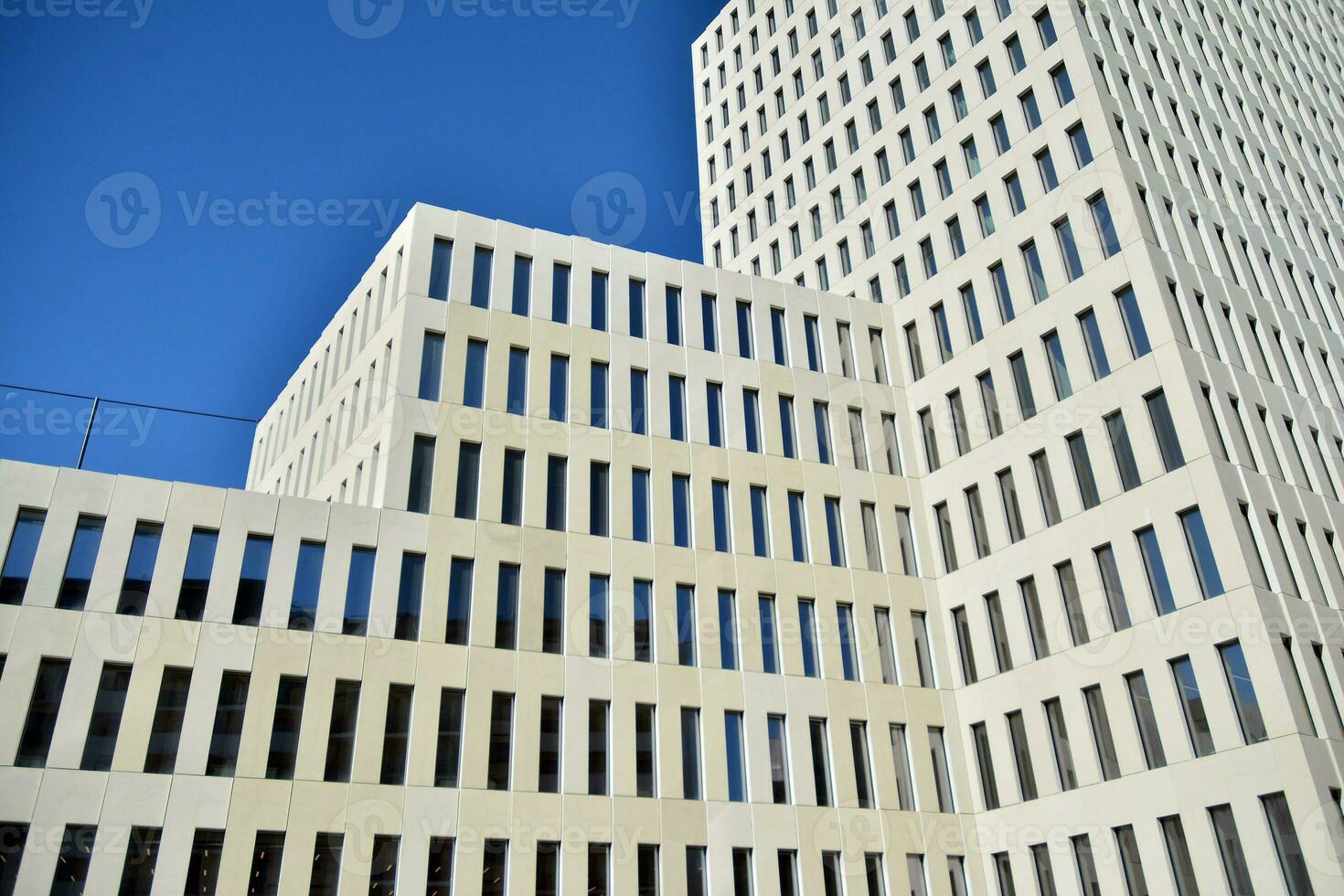 Modern office building detail. Perspective view of geometric angular concrete windows on the facade of a modernist brutalist style building. photo
