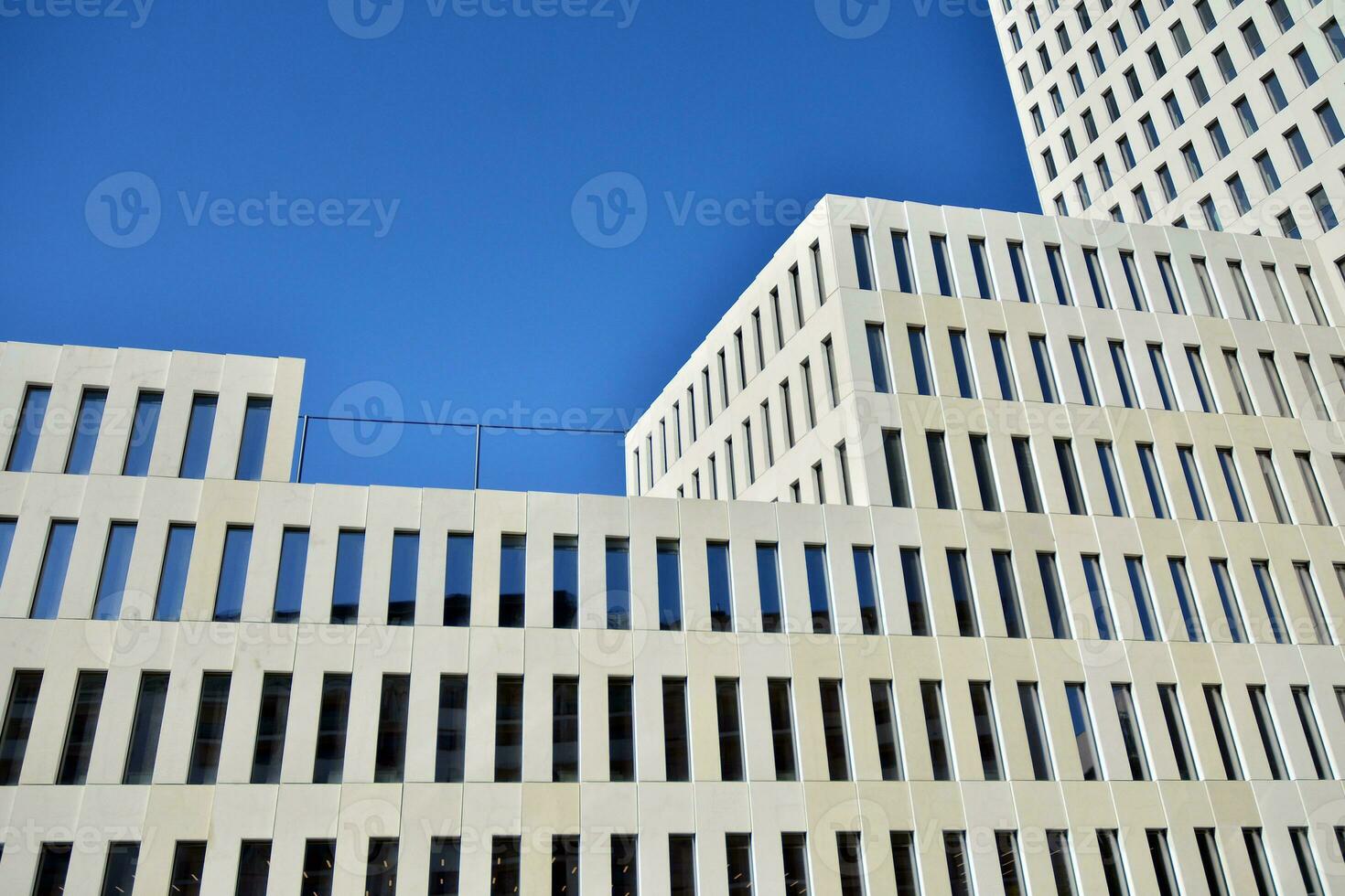 Modern office building detail. Perspective view of geometric angular concrete windows on the facade of a modernist brutalist style building. photo