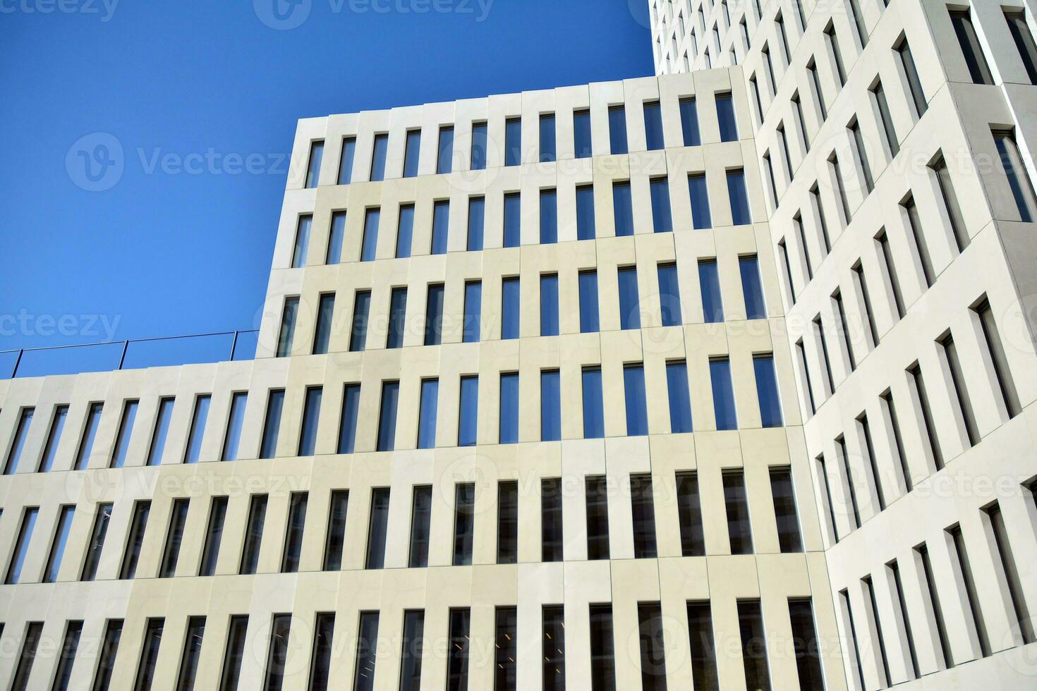 Modern office building detail. Perspective view of geometric angular concrete windows on the facade of a modernist brutalist style building. photo