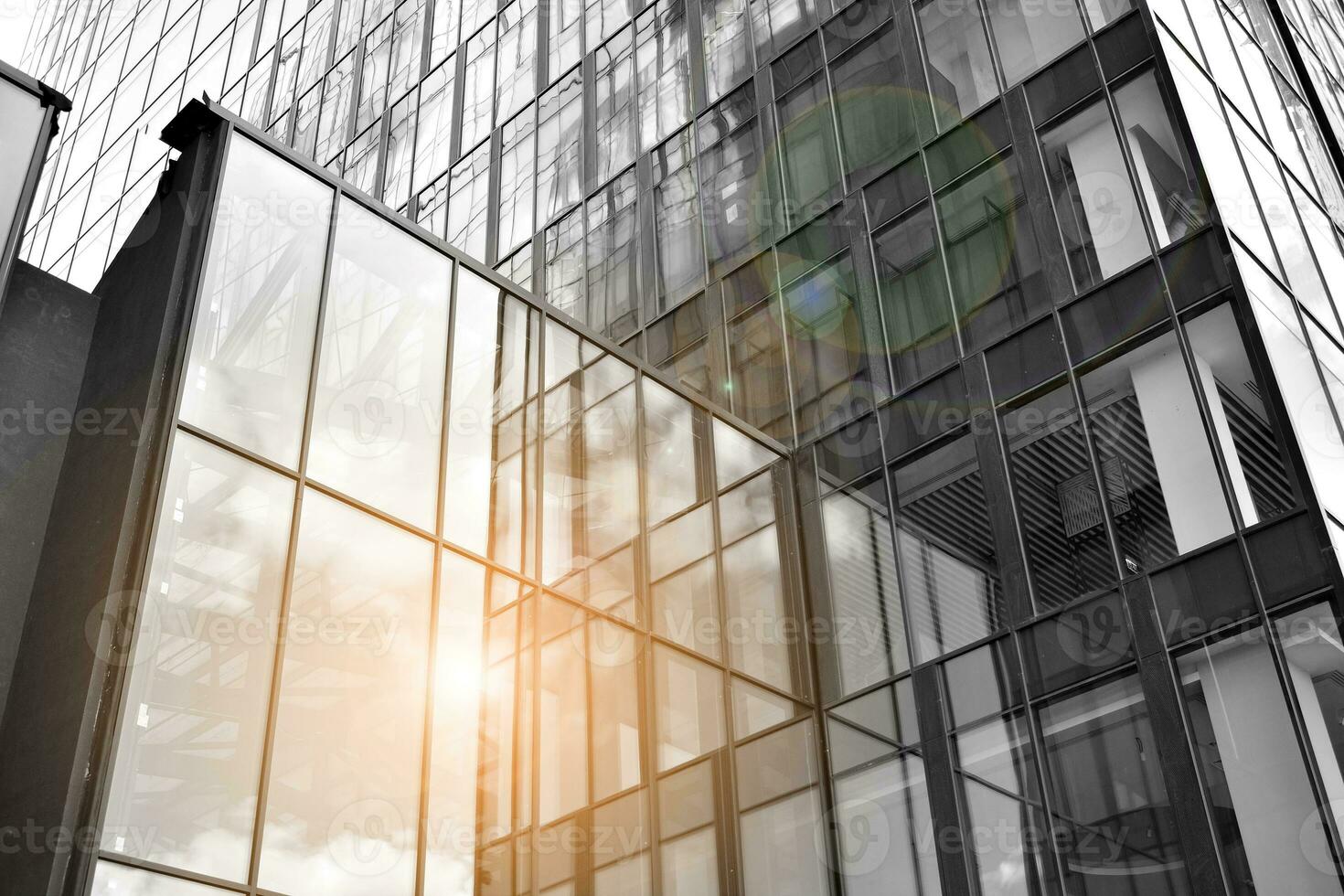 Modern architectural details. Modern glass facade with a geometric pattern. Contemporary corporate business architecture. Red sun on horizon. Black and white toned image. photo