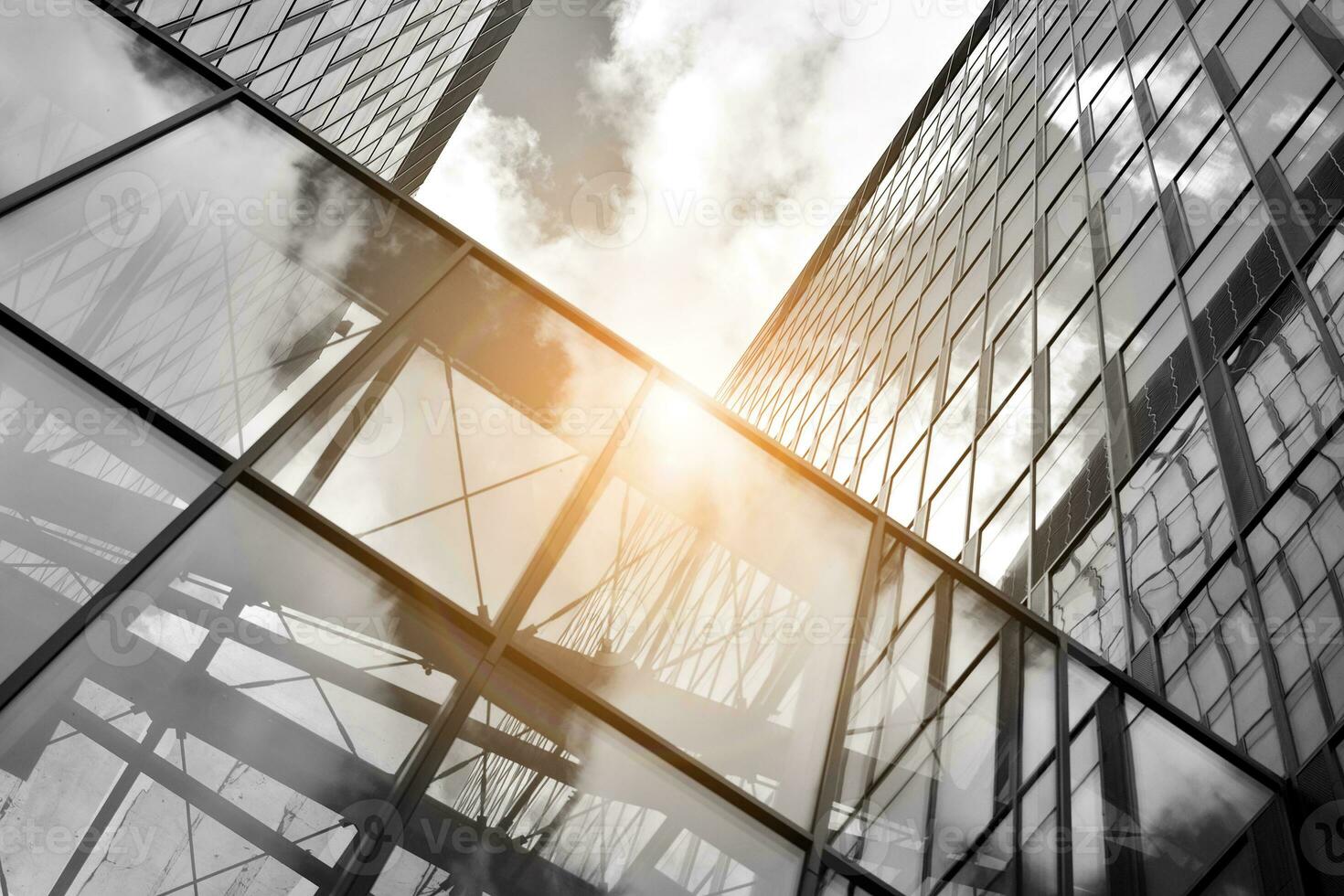 Modern architectural details. Modern glass facade with a geometric pattern. Contemporary corporate business architecture. Red sun on horizon. Black and white toned image. photo