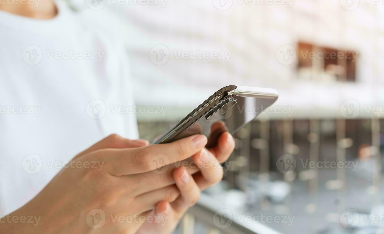 Woman's hands holding smartphone and using a social media at night street. photo