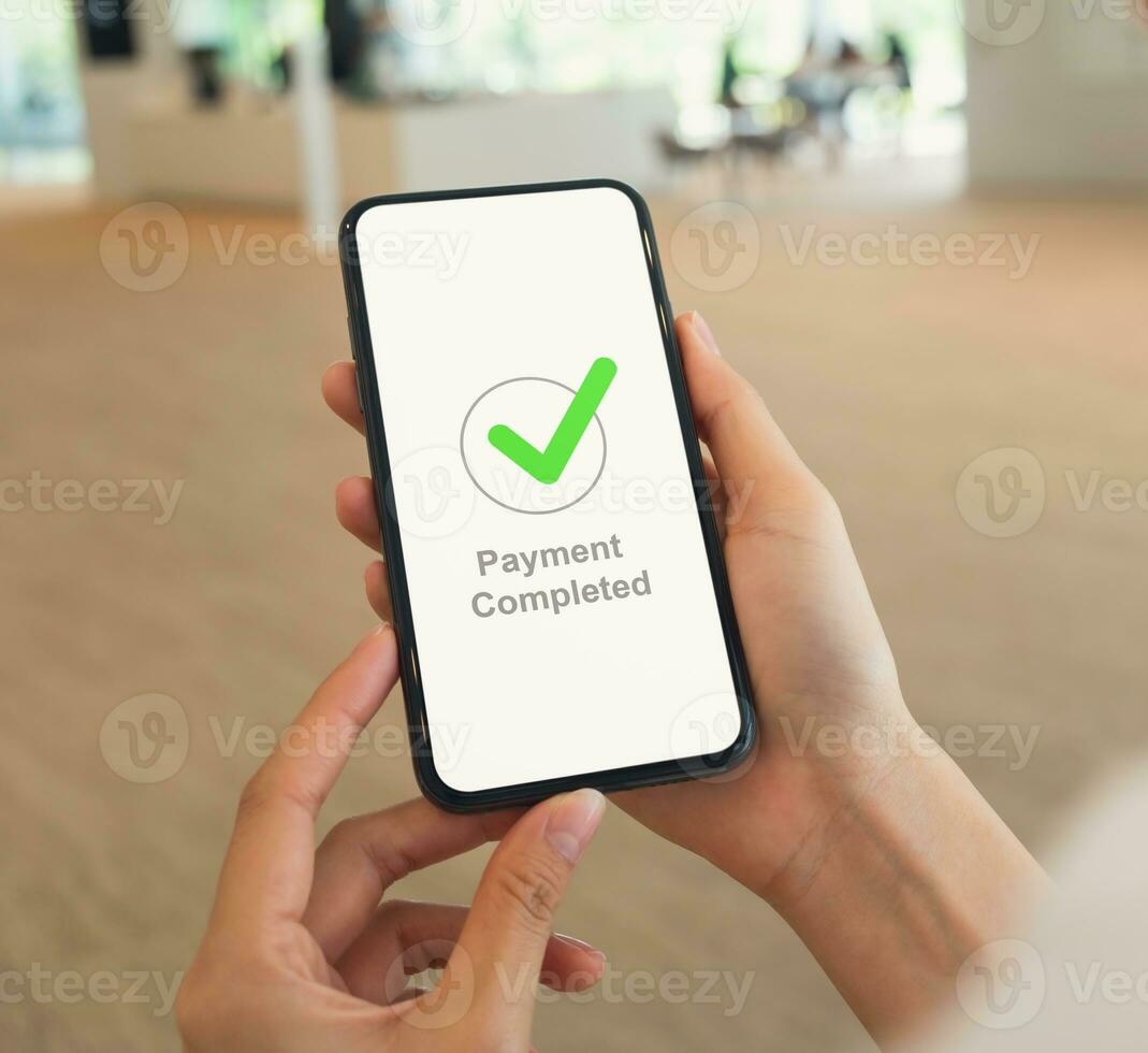 Woman hands hold smartphone and showing payment completed message on mobile. photo