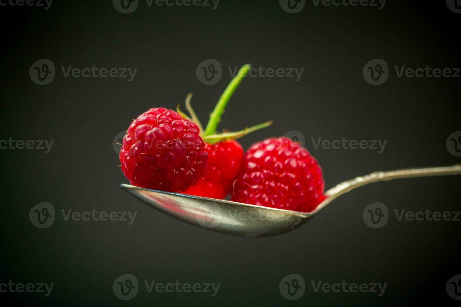 Sweet raspberry fruit isolated on black background photo