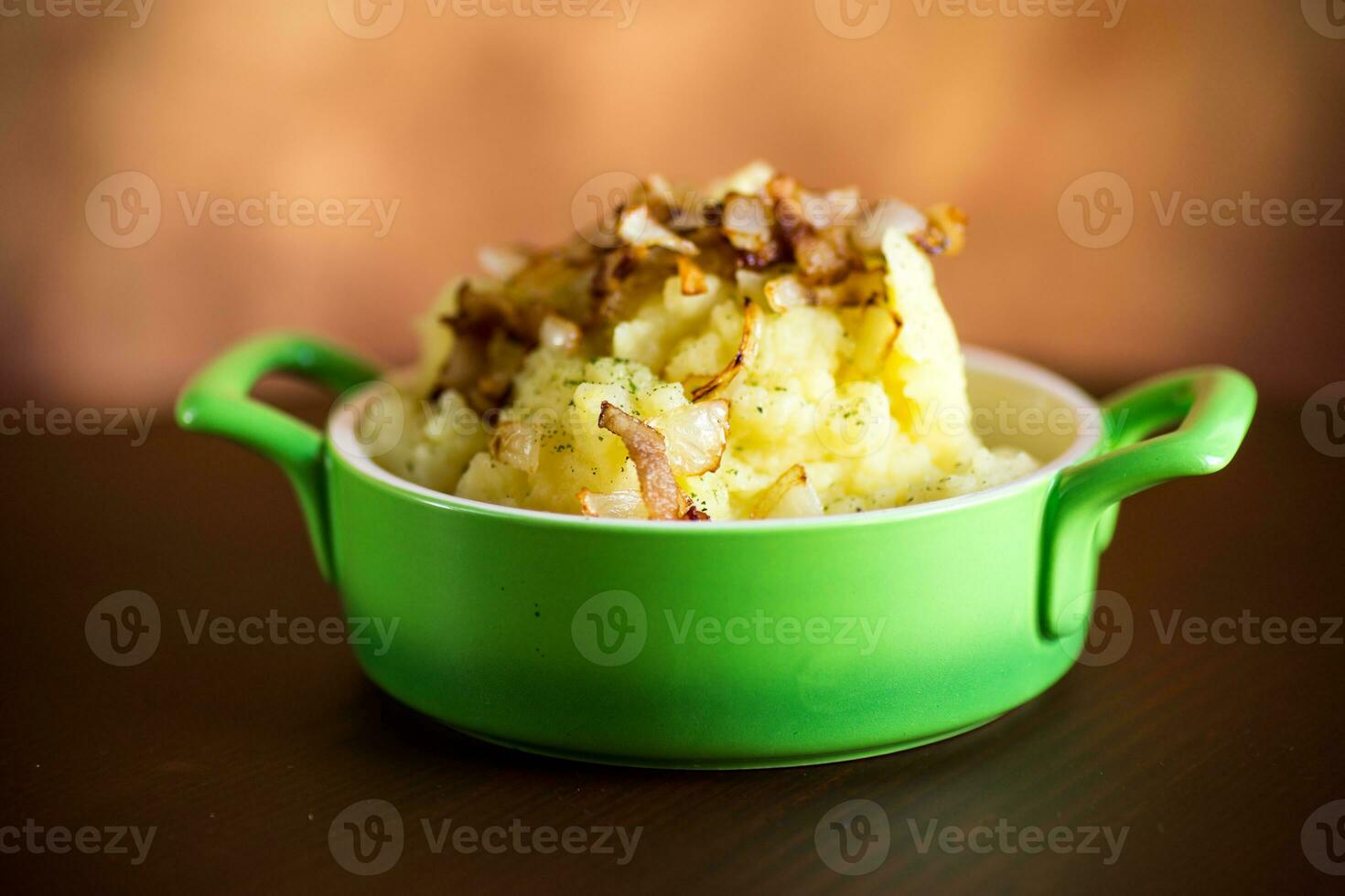 cocido machacado patatas con frito Cortado tocino y cebollas. foto