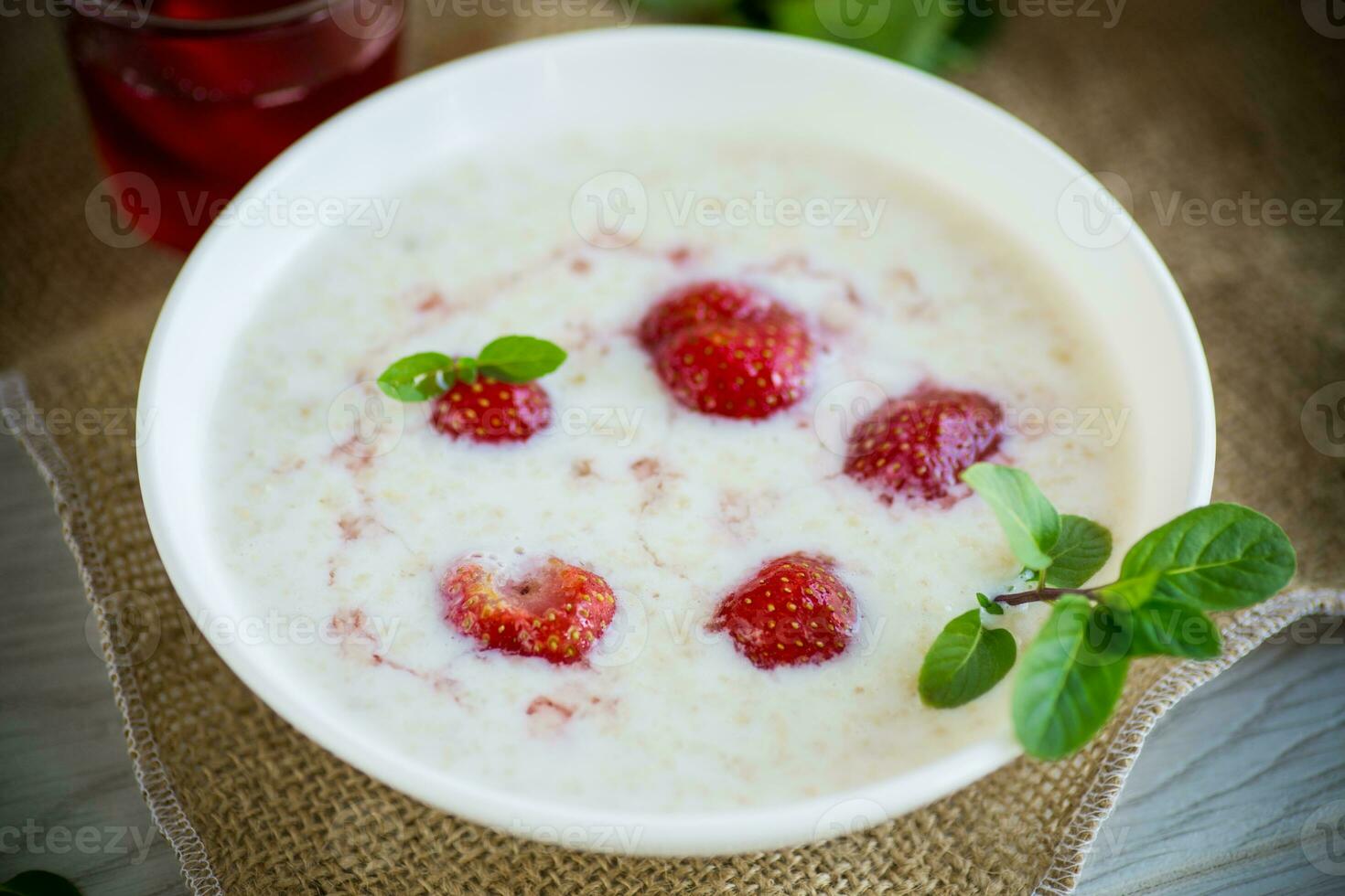 sweet milk oatmeal with strawberries in a plate photo