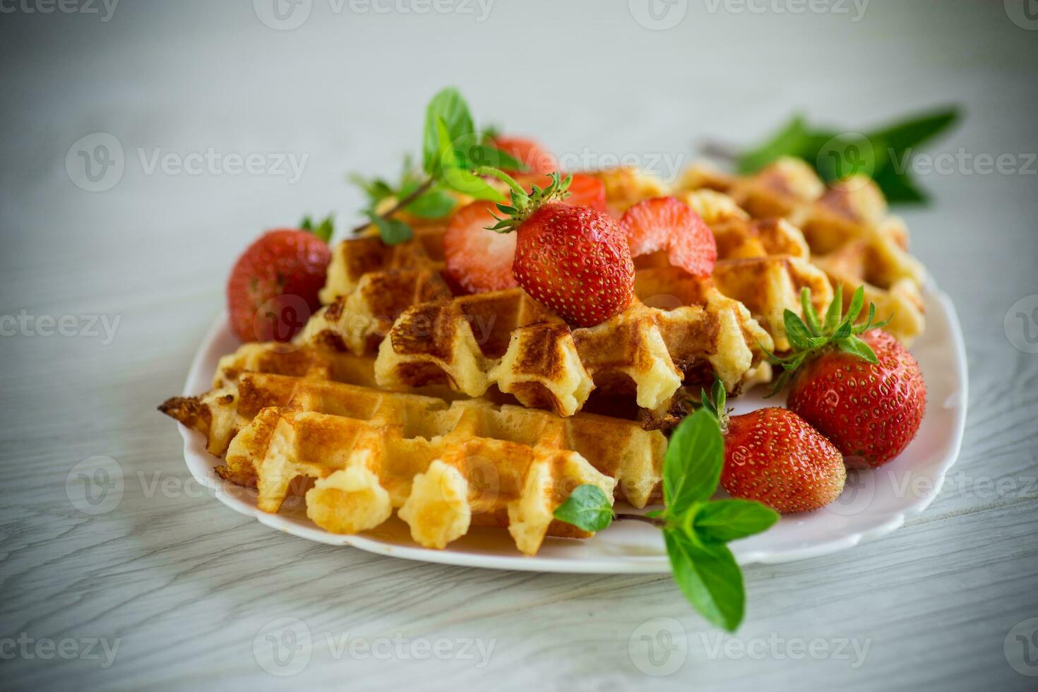 Sweet curd cooked waffles with fresh ripe strawberries photo