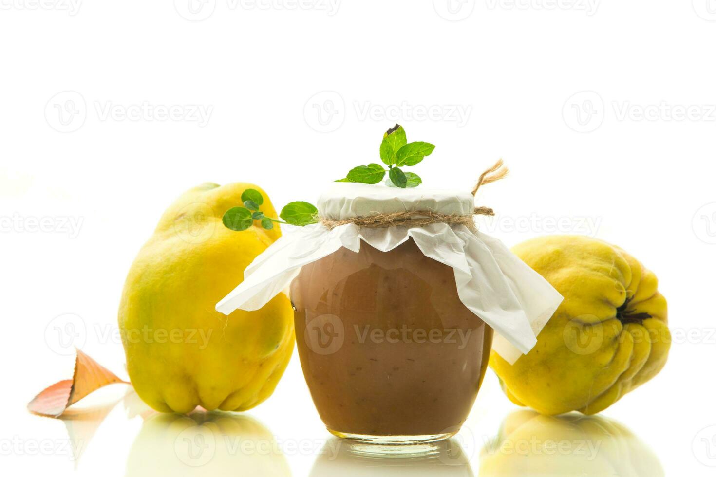 Ripe quince fruit with jam in a glass jar isolated on a white background. photo