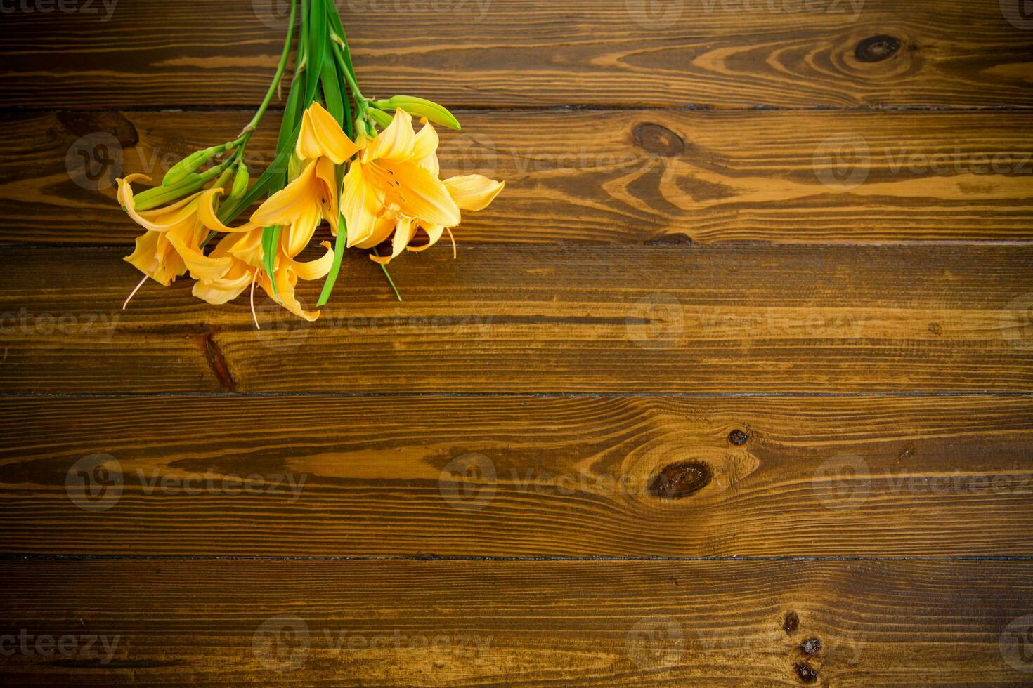 bouquet of beautiful yellow lilies on wooden table photo