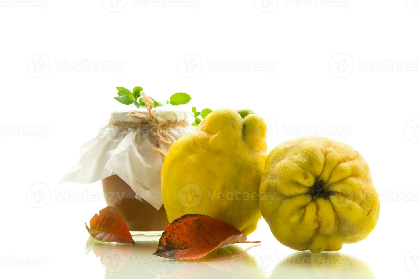 Ripe quince fruit with jam in a glass jar isolated on a white background. photo