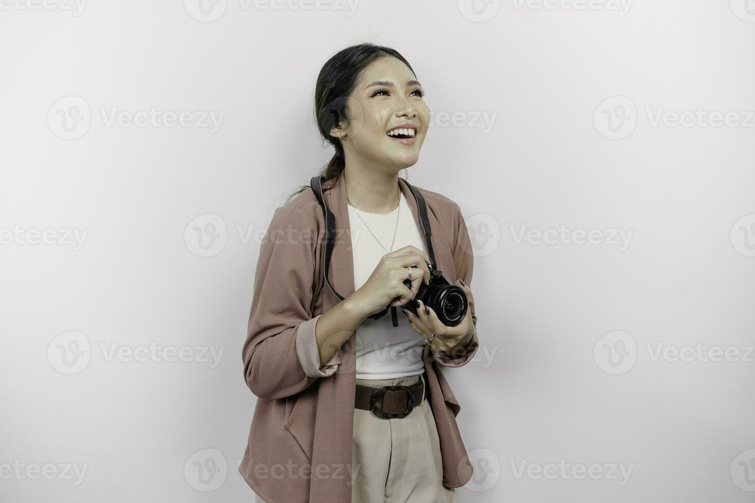 alegre joven asiático mujer turista en pie con cámara tomando foto aislado en blanco estudio antecedentes