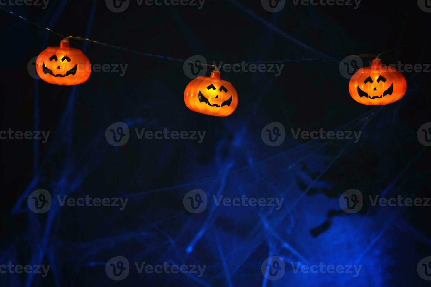 Garland with orange pumpkins on the background of cobwebs photo