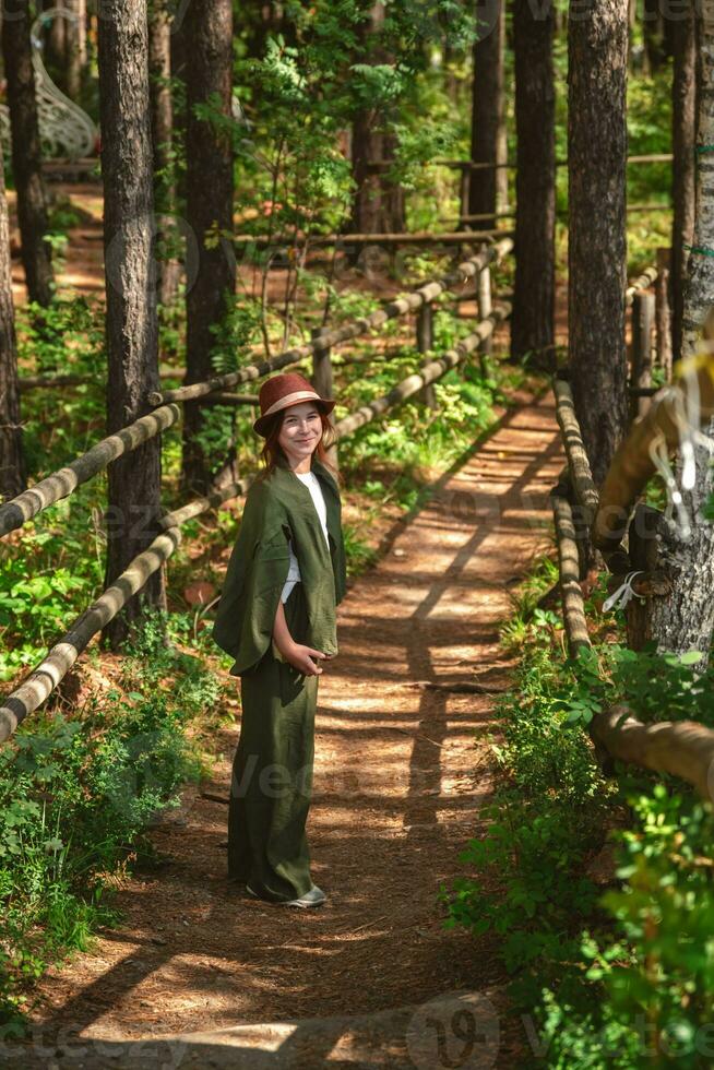 Cute teenage girl walking along a beautiful ladder in the forest photo