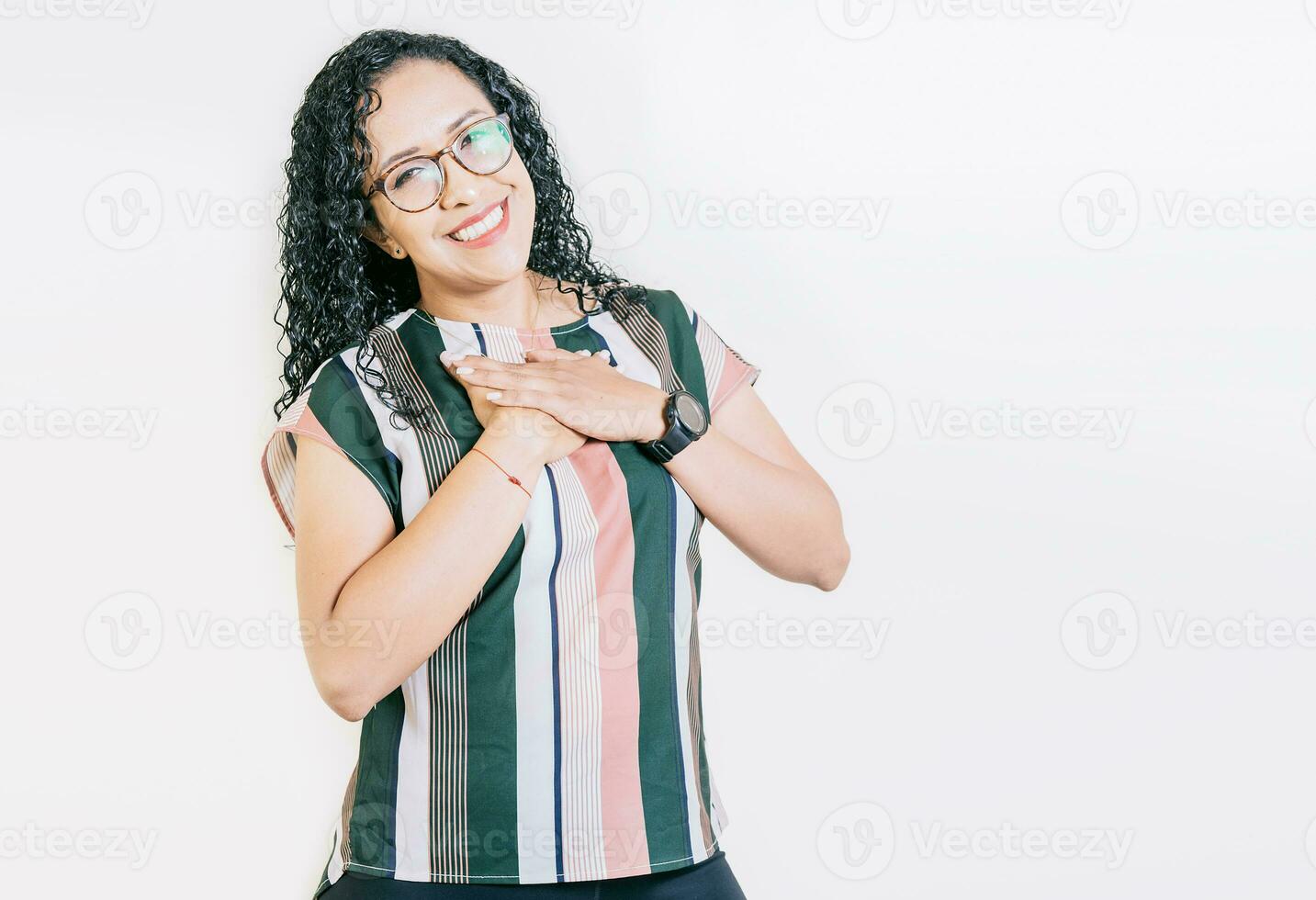 agradecido joven mujer sonriente con manos en cofre aislado. positivo sonriente niña con manos en pecho. agradecido personas con manos en cofre foto