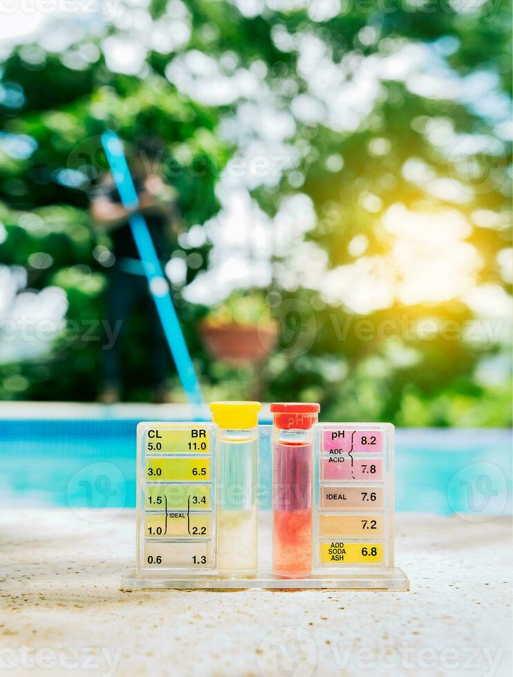 Pool water PH tester kit on the edge of the swimming pool. Tester kit to measure chlorine and ph in swimming pools photo
