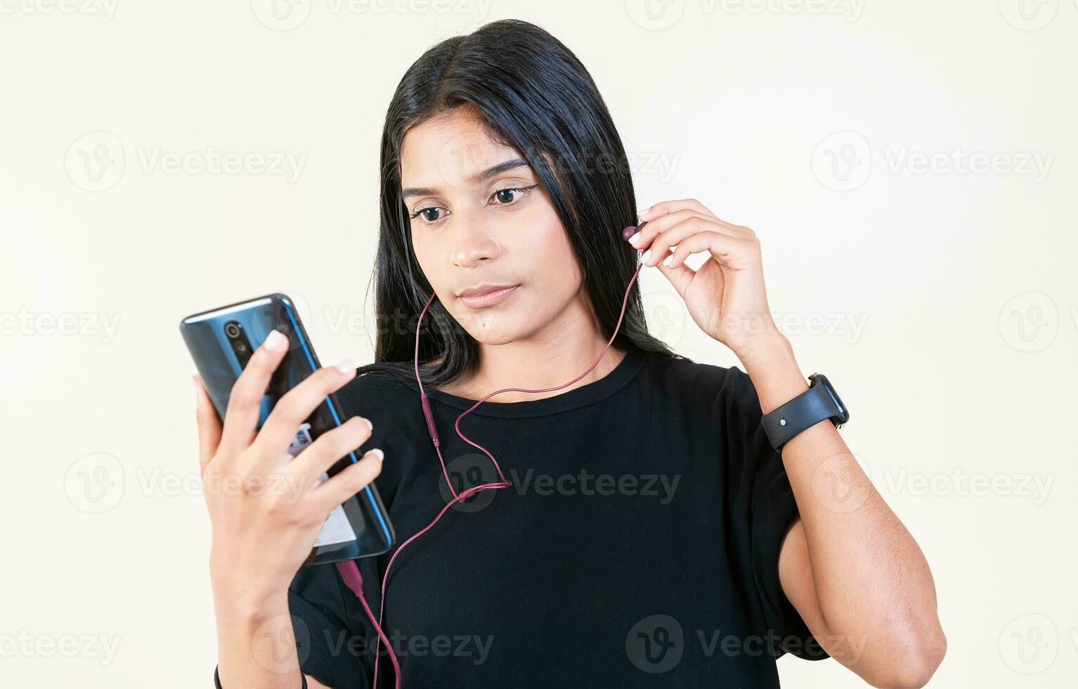 latín niña disfrutando música con teléfono aislado. retrato de hermosa niña escuchando a música con teléfono inteligente aislado. contento latín gir escuchando a música con célula teléfono aislado foto