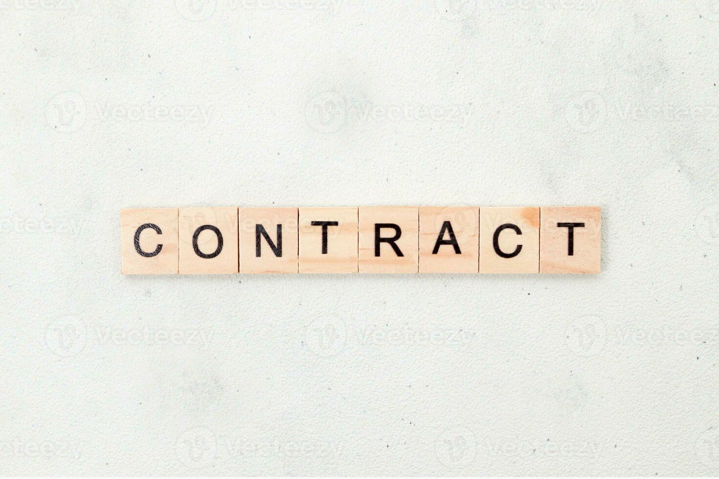Top view of contract word on wooden cube letter block on white background. Business concept photo