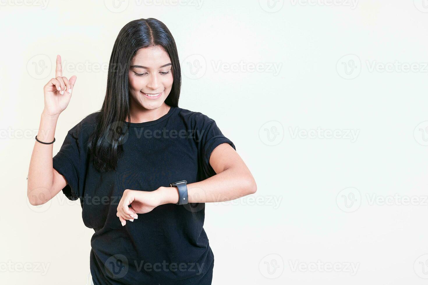 Happy latin girl looking at hand watch isolated. Smiling teen girl looking at hand watch isolated photo