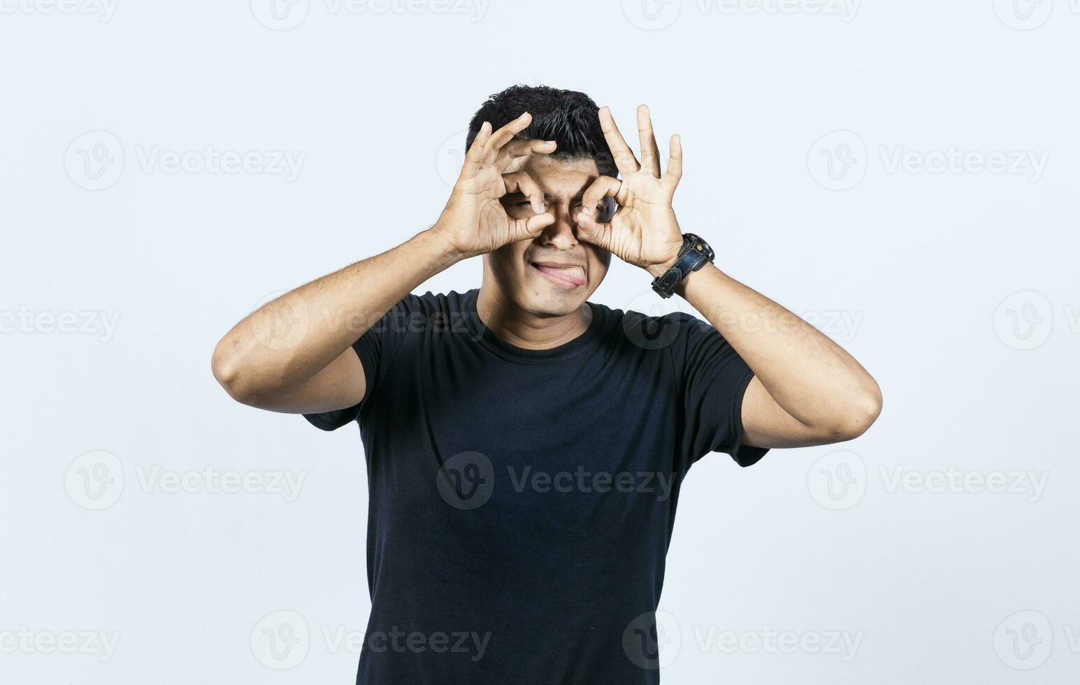 Curious man making binoculars gesture, Guy on isolated background making binoculars gesture, Man making binoculars gesture, man using his fists as binoculars photo