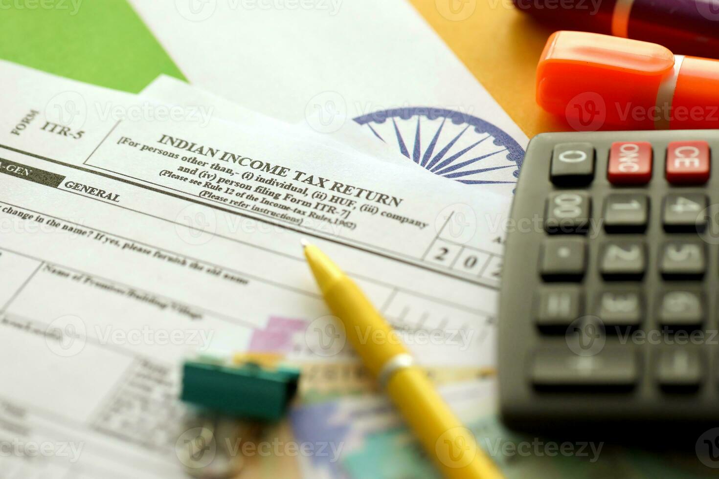 Indian income tax return blank form with pen and indian rupees bills photo