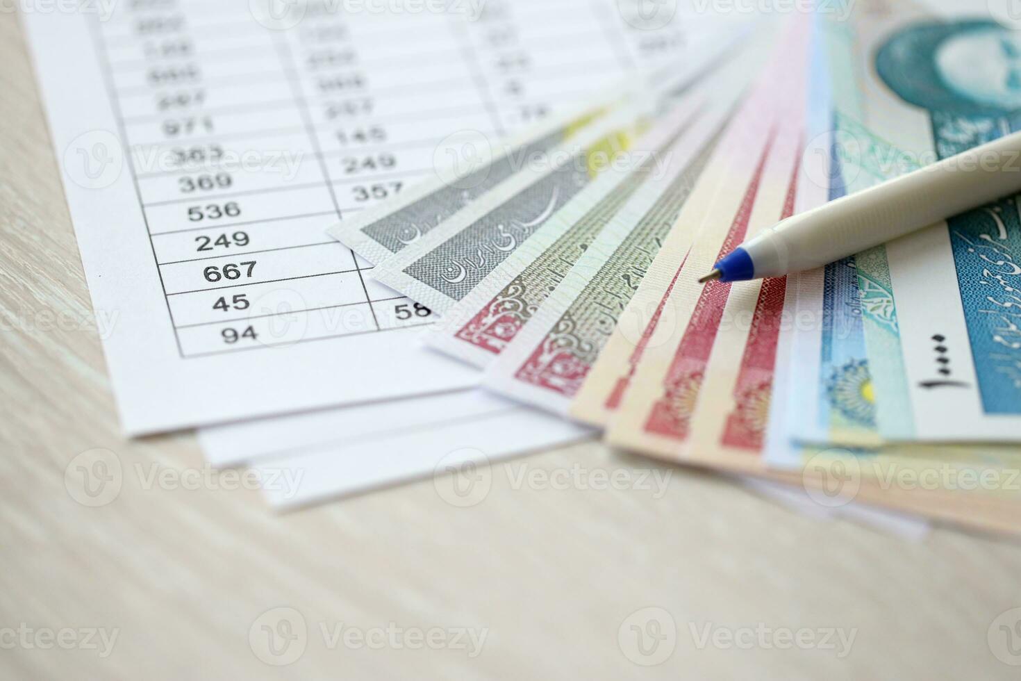 Iranian business calculations on table with iranian money and pen photo