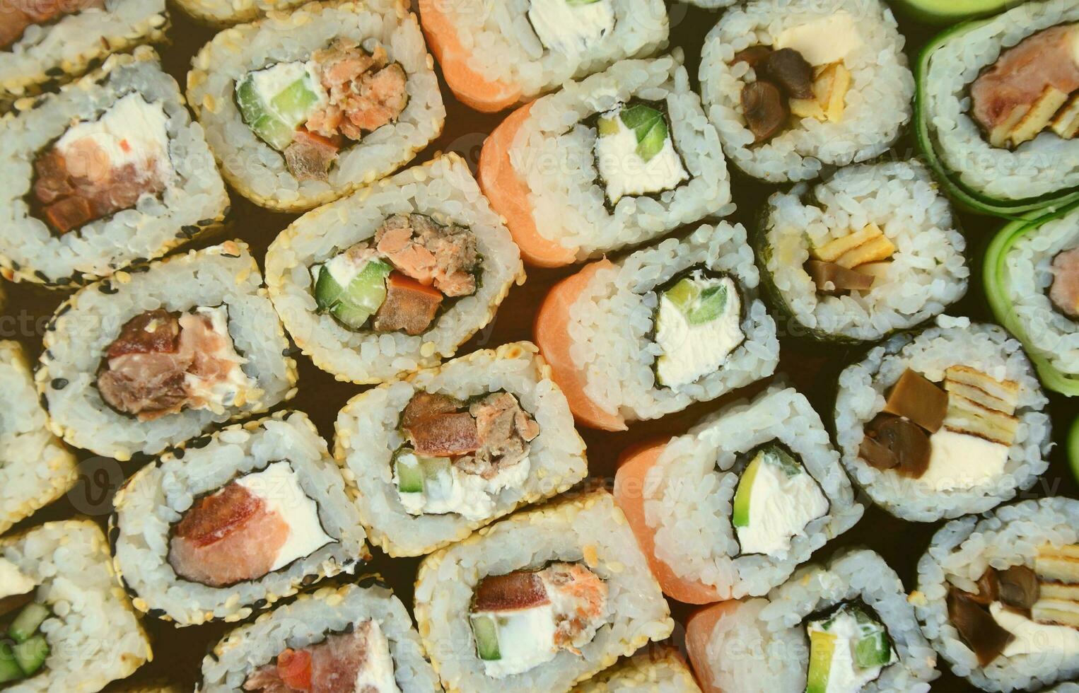 Close-up of a lot of sushi rolls with different fillings. Macro shot of cooked classic Japanese food. Background image photo