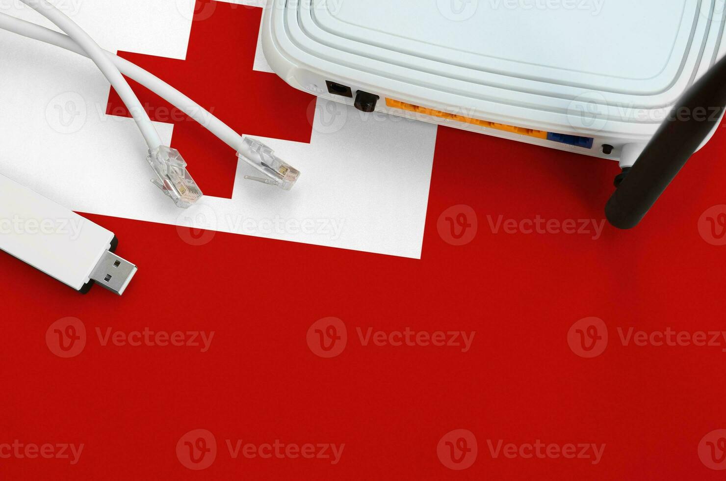 Tonga flag depicted on table with internet rj45 cable, wireless usb wifi adapter and router. Internet connection concept photo