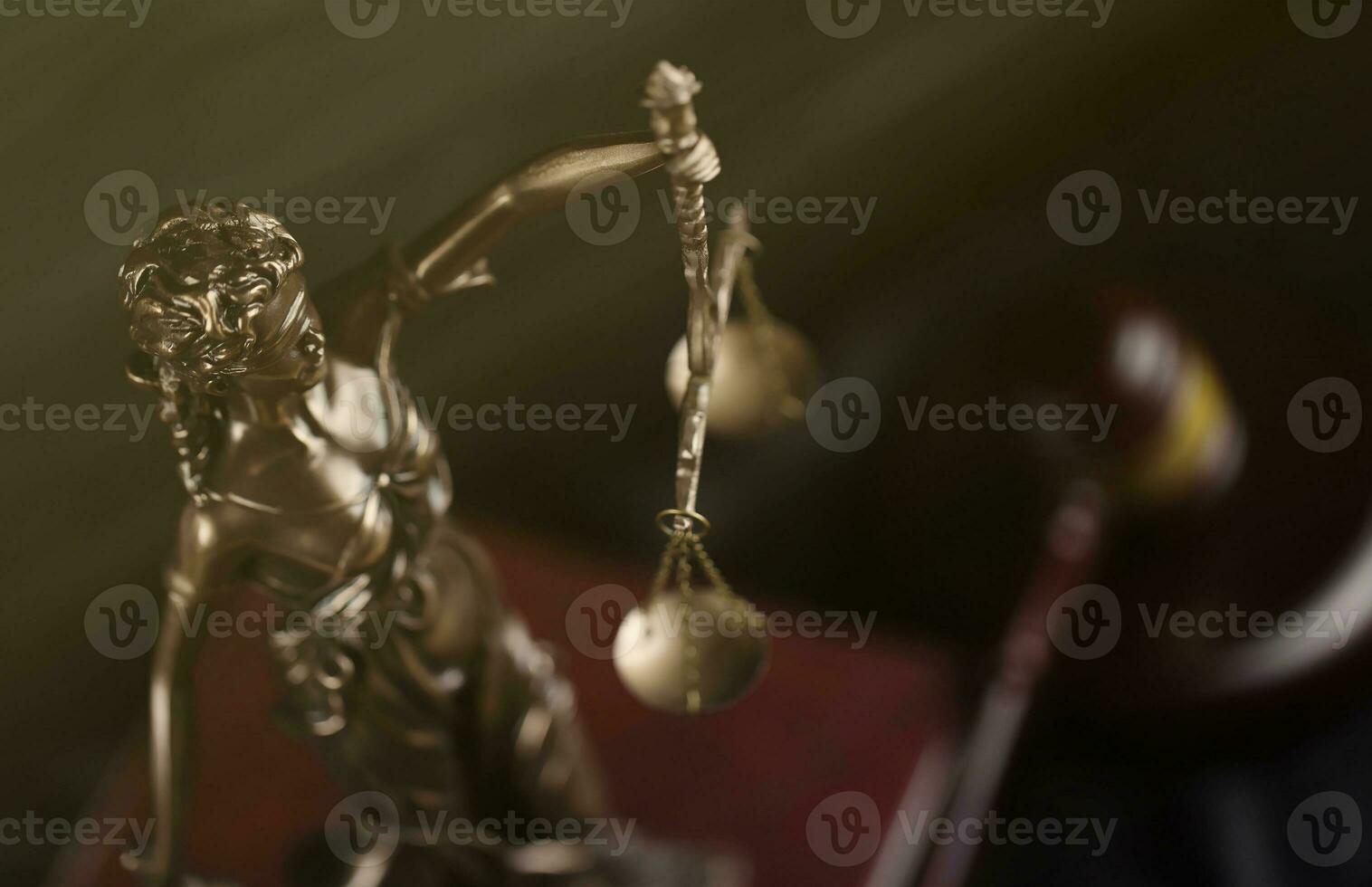 The Statue of Justice - lady justice or justitia the Roman goddess of Justice. Statue on brown book with judge gavel. Concept of judicial trial, courtroom process and lawyers work photo
