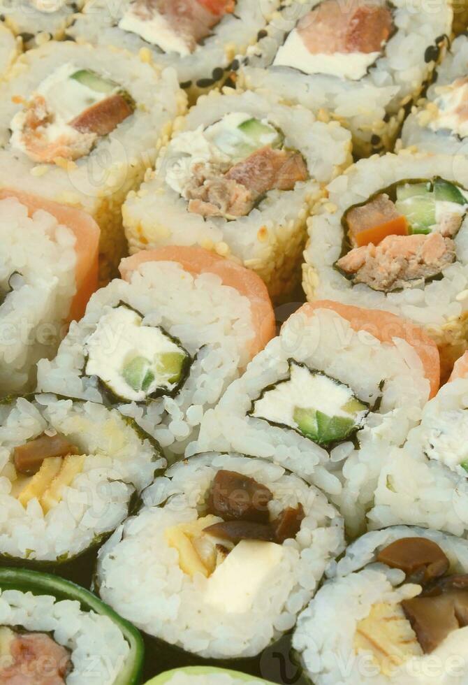 Close-up of a lot of sushi rolls with different fillings. Macro shot of cooked classic Japanese food. Background image photo