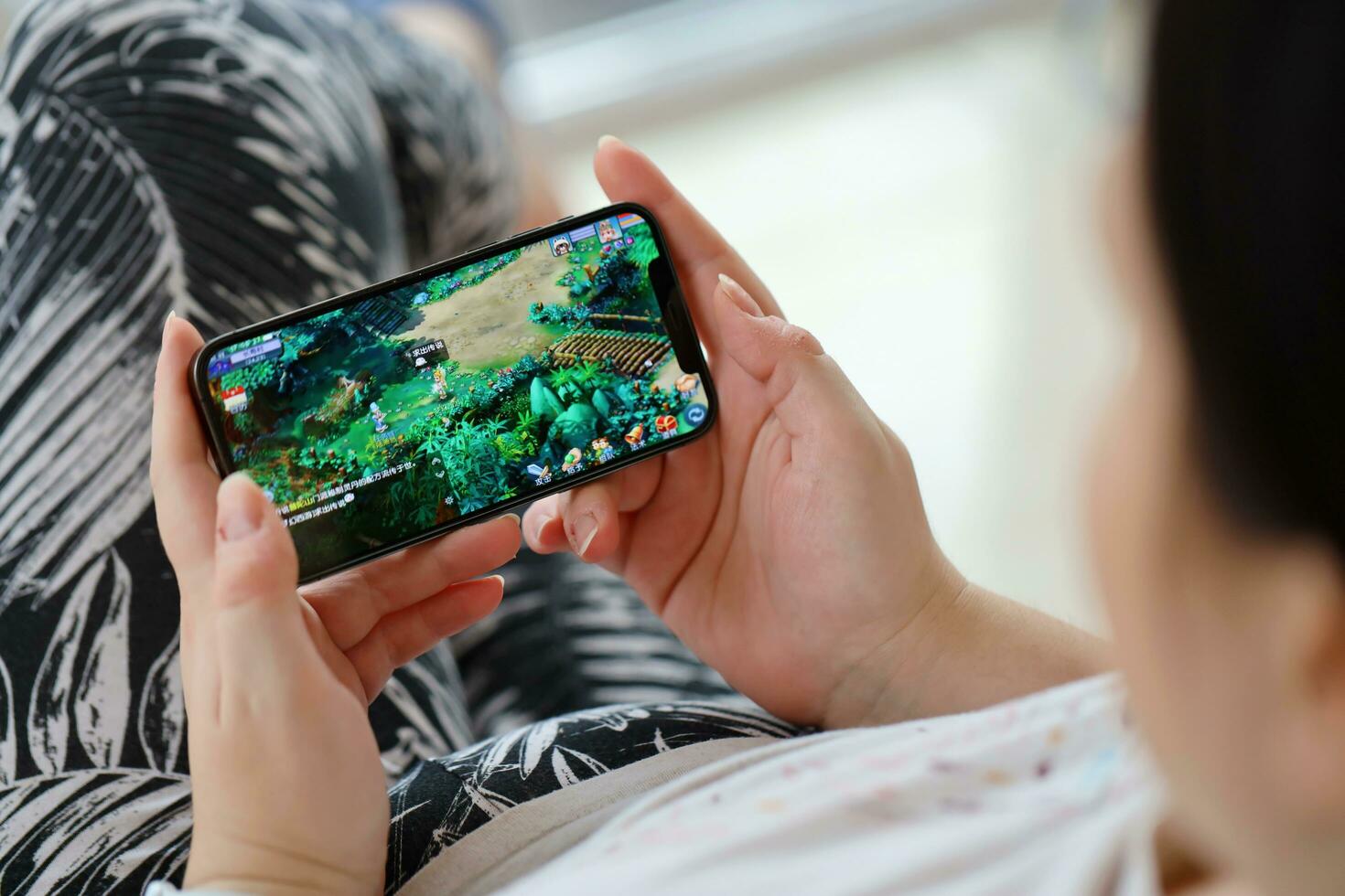 Fantasy Westward Journey mobile iOS game on iPhone 15 smartphone screen in female hands during mobile gameplay photo