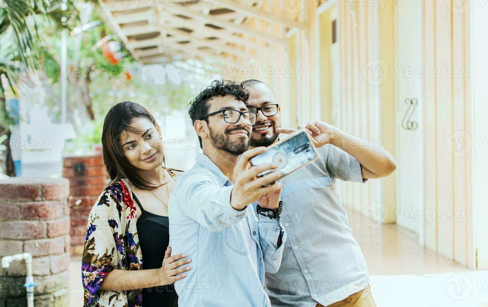 Tres amigos tomando un selfie afuera, Tres sonriente amigos tomando un selfie en el calle. frente ver de Tres alegre amigos tomando un selfie en el calle. amigos selfie concepto. foto