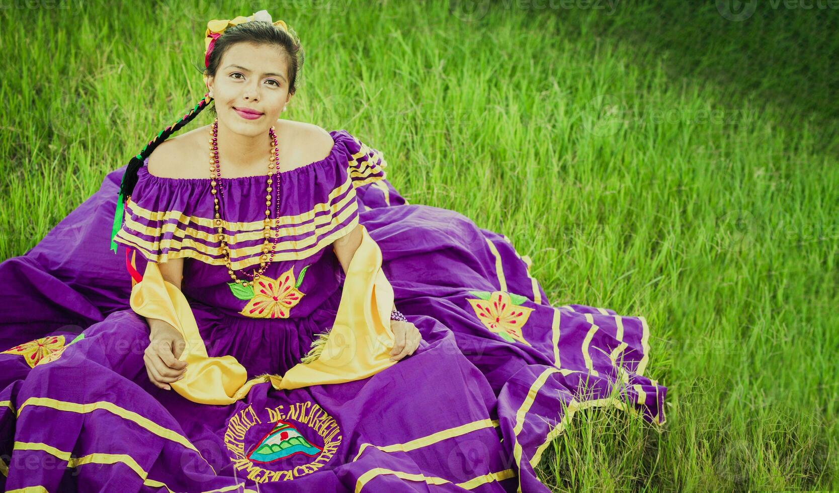 retrato de nicaragüense niña en gente disfraz sentado en el césped, joven nicaragüense niña en tradicional gente disfraz sentado en el césped en el campo foto