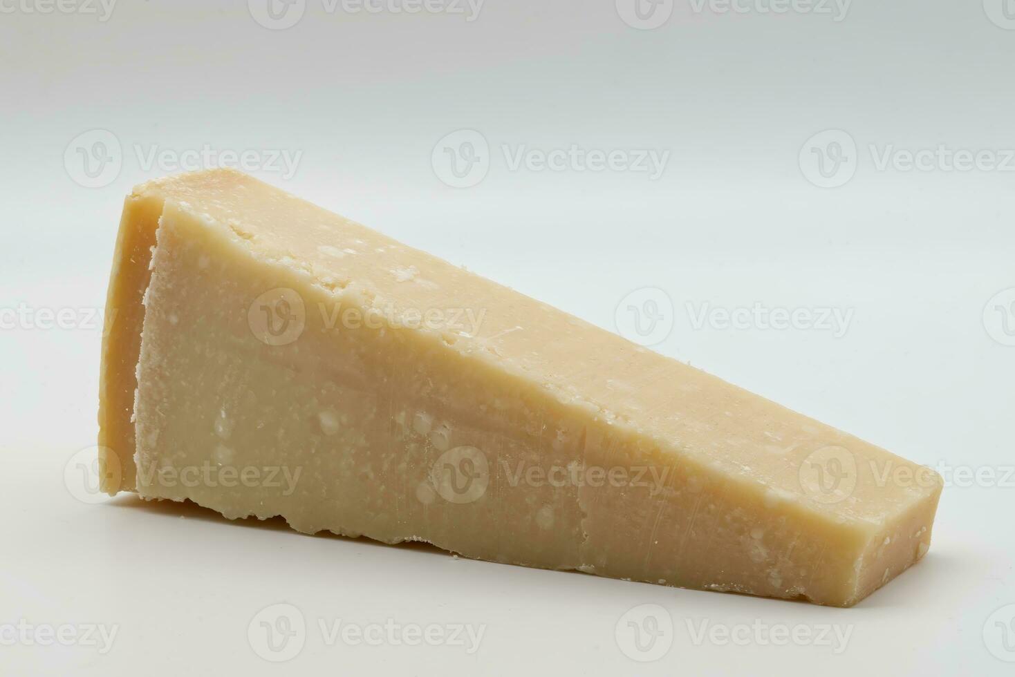 Slice of Italian Parmigiano Reggiano cheese isolated on white background photo