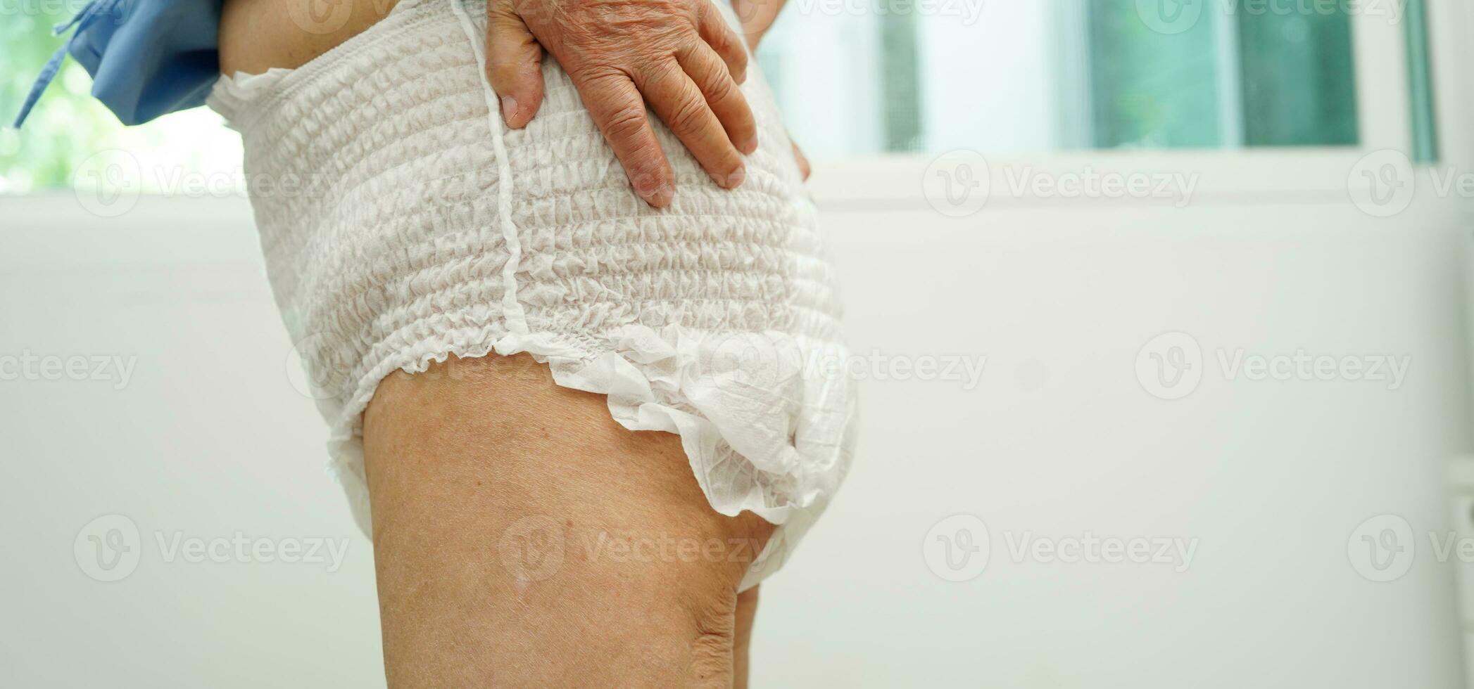 Asian senior woman patient wearing adult incontinence diaper pad in hospital. photo